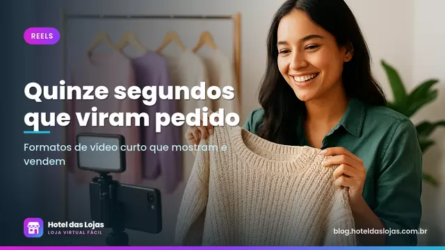 Empreendedora gravando vídeo de produto com celular no tripé, segurando um suéter em frente a uma arara de roupas