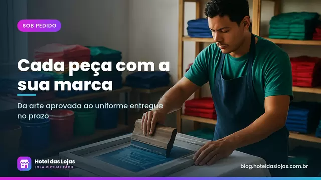 Oficina de estamparia com profissional estampando camiseta branca e pilhas de camisetas e uniformes ao fundo